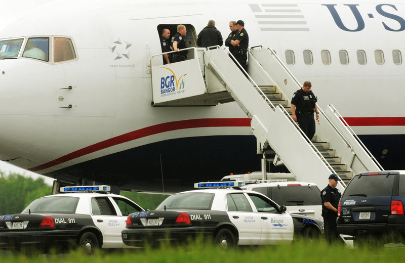 Law enforcement officials converge on a passenger jet on the tarmac at Bangor International Airport on Tuesday.