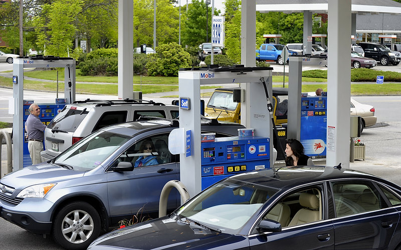 Motorists, including Hailey Elliott of Cape Elizabeth, right, fill up at Jonesy’s Mobil in Cape Elizabeth on Wednesday. A price war between Jonesy’s and Cumberland Farms has been attracting a number of out-of-town customers.