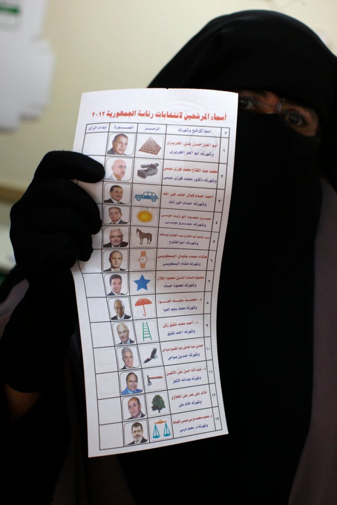 An Egyptian woman holds the ballot paper with names of the 13 presidential candidates at a polling station in Cairo on Thursday.