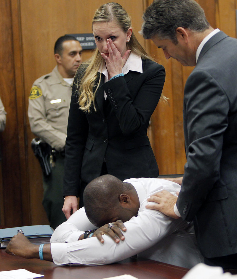 Brian Banks weeps as his attorney Justin Brooks, right, and attorney Alissa Bjerkhoel react as Banks’ rape conviction is dismissed Thursday in Long Beach, Calif. A childhood friend had falsely accused him.