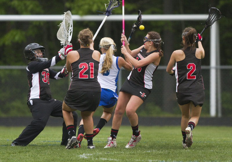 Rose Bryant of Kennebunk is surrounded by two Scarborough defenders, as well as goalie Meg Kirsh, who made eight saves.