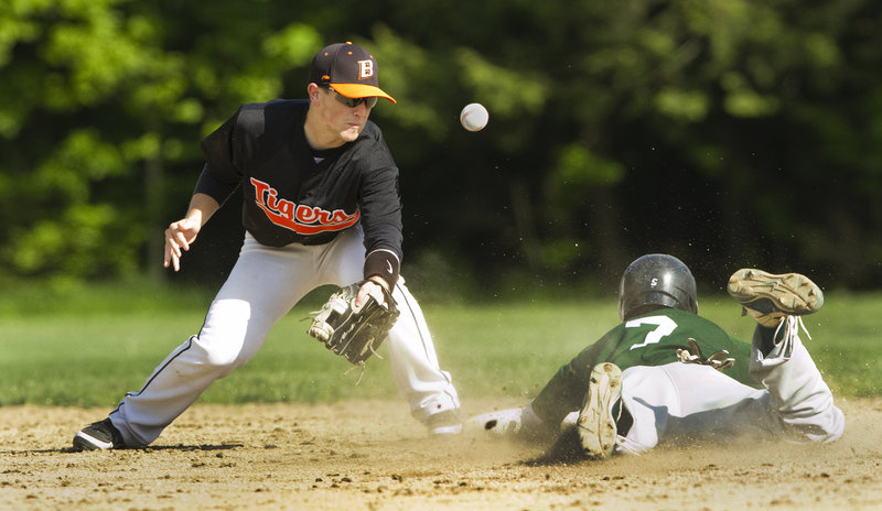 Nathan Peasley of Bonny Eagle slides safely into second for a stolen base Thursday as the throw gets past Biddeford shortstop Corey Greenleaf. Bonny Eagle scored twice in the sixth to win the Telegram League game, 3-2.