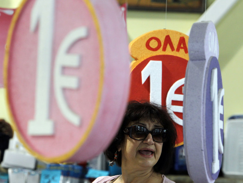 Signs advertising merchandise on sale for one euro are seen Friday in a discount shop in central Athens. Uncertainty over Greece’s future in the eurozone has hammered markets ahead of June 17 general elections.