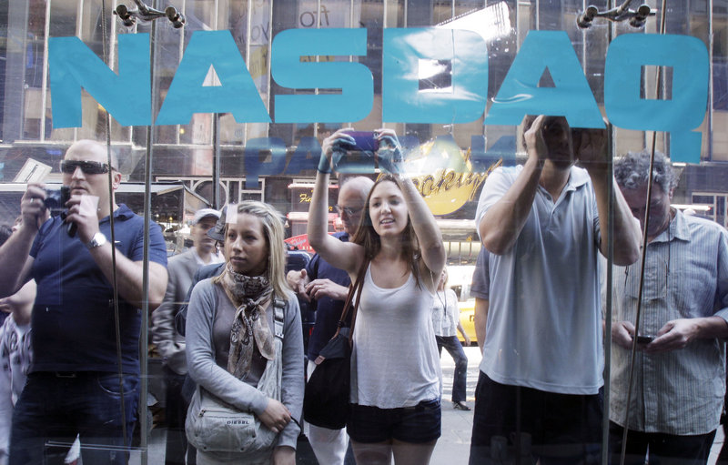 Curious bystanders watch through the Nasdaq windows as Facebook shares began trading on May 18 in New York. It closed at $38.23 that day, up 0.6 percent from the IPO price. On May 25, Facebook stock closed at $31.91, down 3.4 percent for the day, down 16.5 percent for the week and down 16 percent from the IPO price.