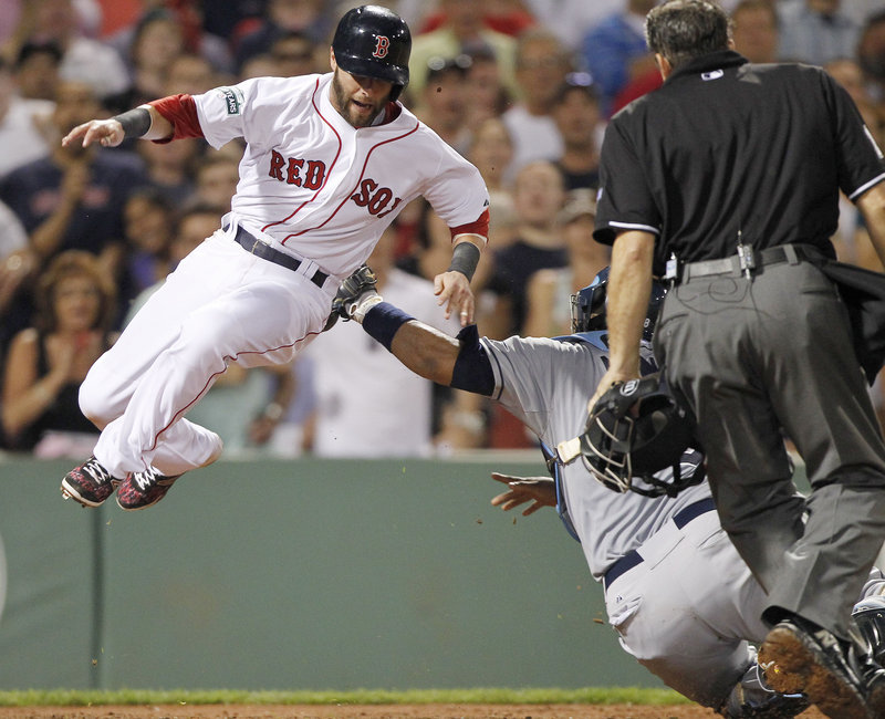 Dustin Pedroia is tagged out by Tampa Bay’s Jose Molina on Saturday night. The Red Sox had the last laugh, as Jarrod Saltalamacchia hit a ninth-inning home run for a 3-2 win.