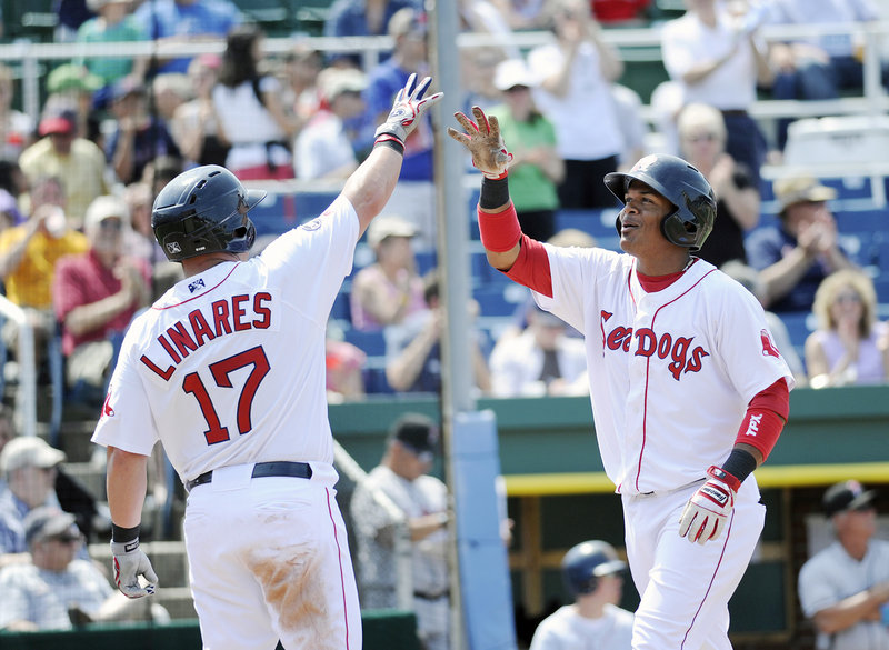 Juan Carlos Linares, left, greets Reynaldo Rodriguez after Rodriguez hit a two-run home run in the fourth inning Sunday. Rodriguez also had a pair of doubles in the 8-5 win over New Britain.