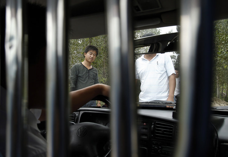 Men block a vehicle from entering the rural Chinese village where blind activist Chen Guangcheng was locked down until his escape last month. The government provides “stability preservation funds” to pay co-workers, neighbors, gang members and others to carry out round-the-clock surveillance of people perceived as a threat by the authorities.