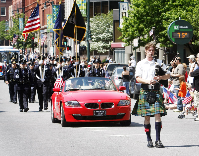 Bagpiper Aaron Seale of South Portland leads the Memorial Day parade down Congress Street. Parade grand marshal John S. Hammonds, a Navy veteran of World War II, follows in the red car.