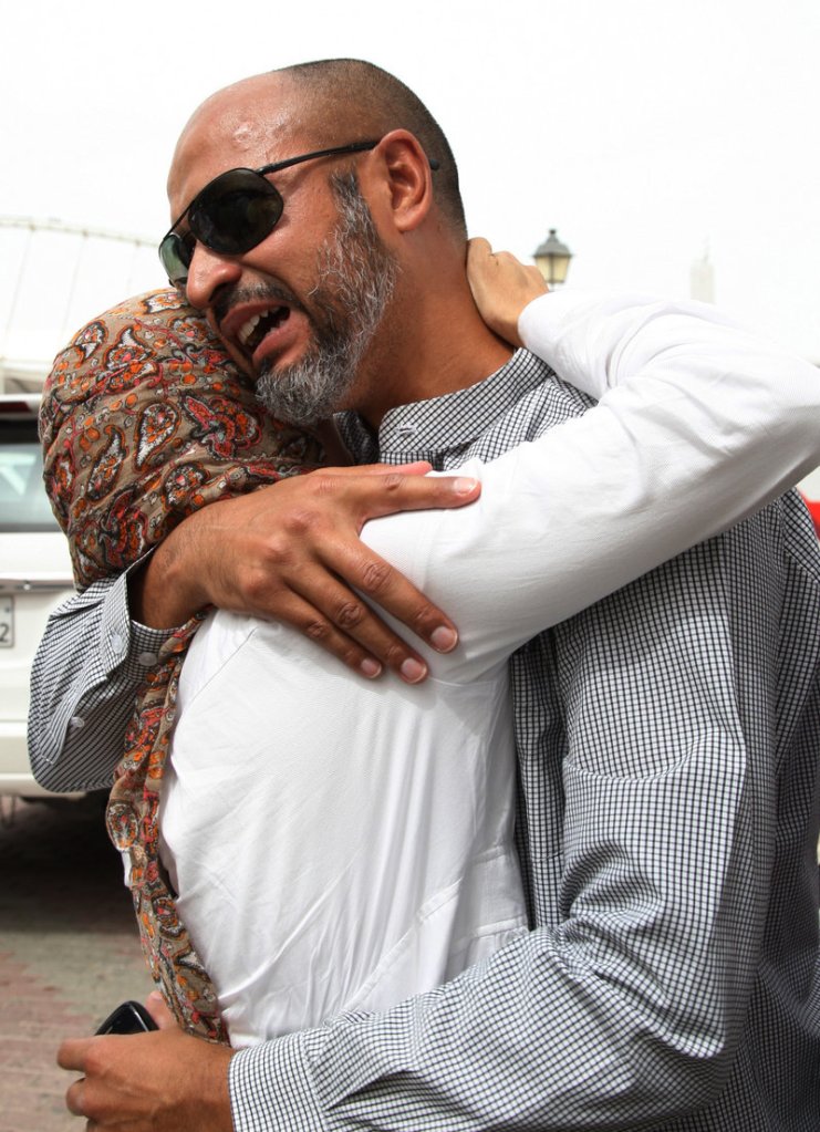 The father of a child killed in a fire at Villaggio mall in Doha, Qatar, is comforted Monday.