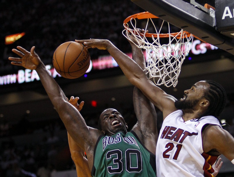 Brandon Bass gets his shot blocked by Miami’s Ronny Turiaf, one of 11 blocked shots for the Heat in their 93-79 win over the Celtics.