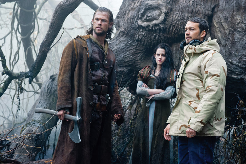 Chris Hemsworth, left, as the Huntsman, and Kristen Stewart as Snow White with director Rupert Sanders on the set of “Snow White and the Huntsman.”