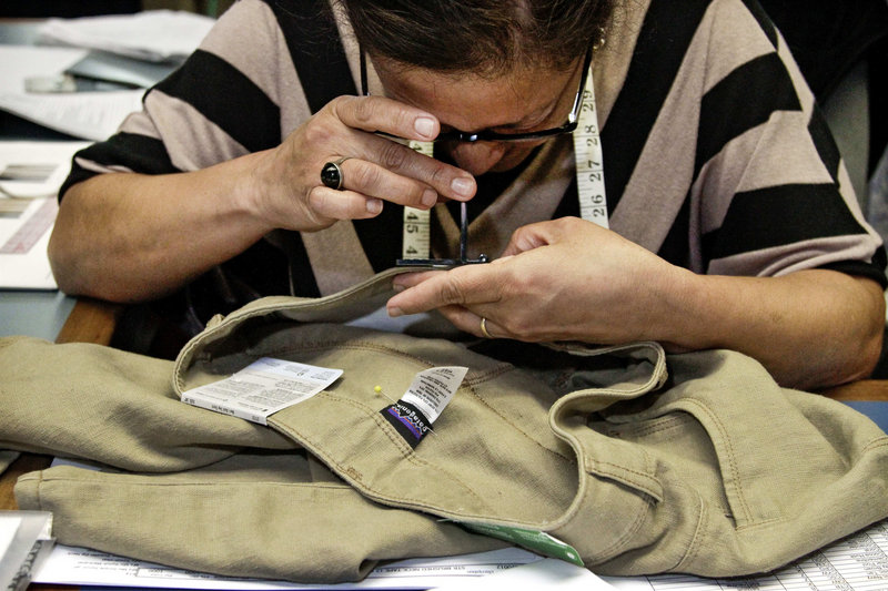 Quality-control employee Nellie Castillo counts stitches per inch on a pair of pants at Patagonia headquarters in Ventura, Calif. The company is known for well-made goods and its almost fanatical environmentalism.