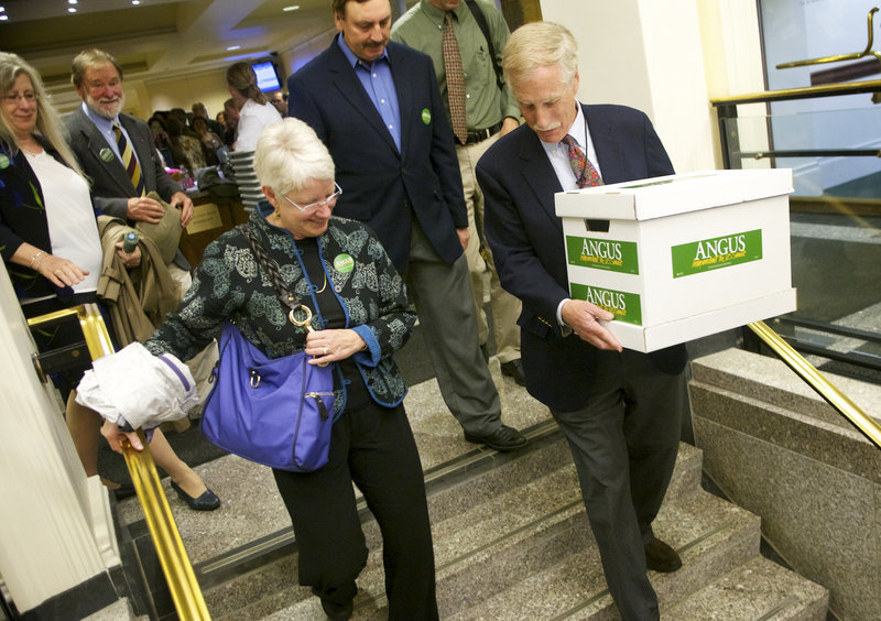 Former Gov. Angus King carries a box of signature-filled petitions to the Cross Building in Augusta on Tuesday morning to get himself on the ballot in this fall’s race to replace Sen. Olympia Snowe, R-Maine, who is retiring.