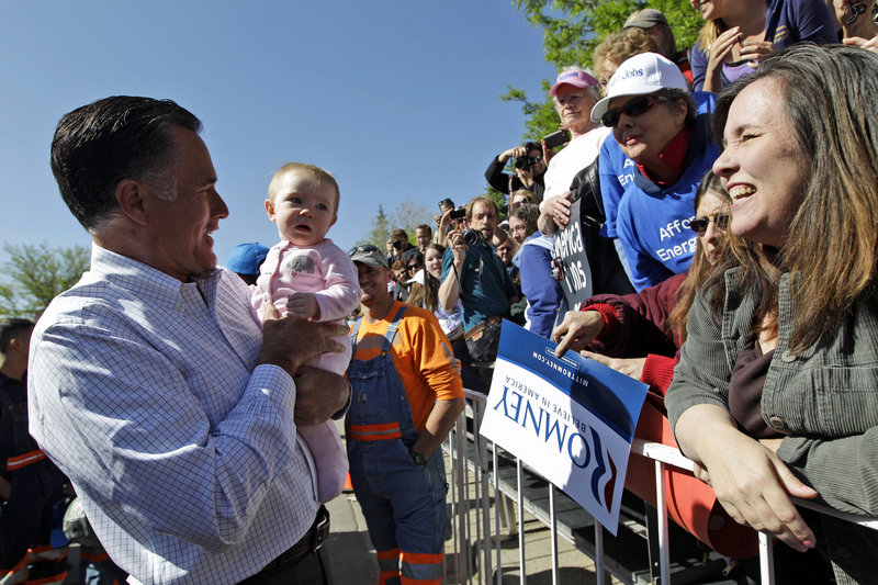 Mitt Romney holds a baby as he greets supporters after speaking at a campaign event Tuesday in Craig, Colo.