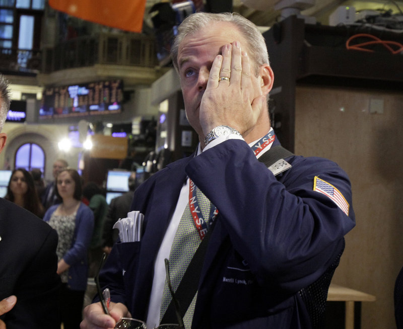 Trader David O’Day works Wednesday on the New York Stock Exchange floor. The Dow Jones closed down 161 points.