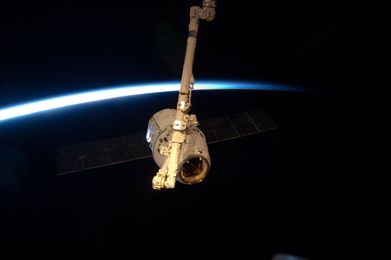 With a thin line of Earth’s atmosphere forming a backdrop, the SpaceX Dragon commercial cargo craft is grappled by a robotic arm at the International Space Station last Friday. It was due to return to Earth today, carrying back old equipment and experiments.