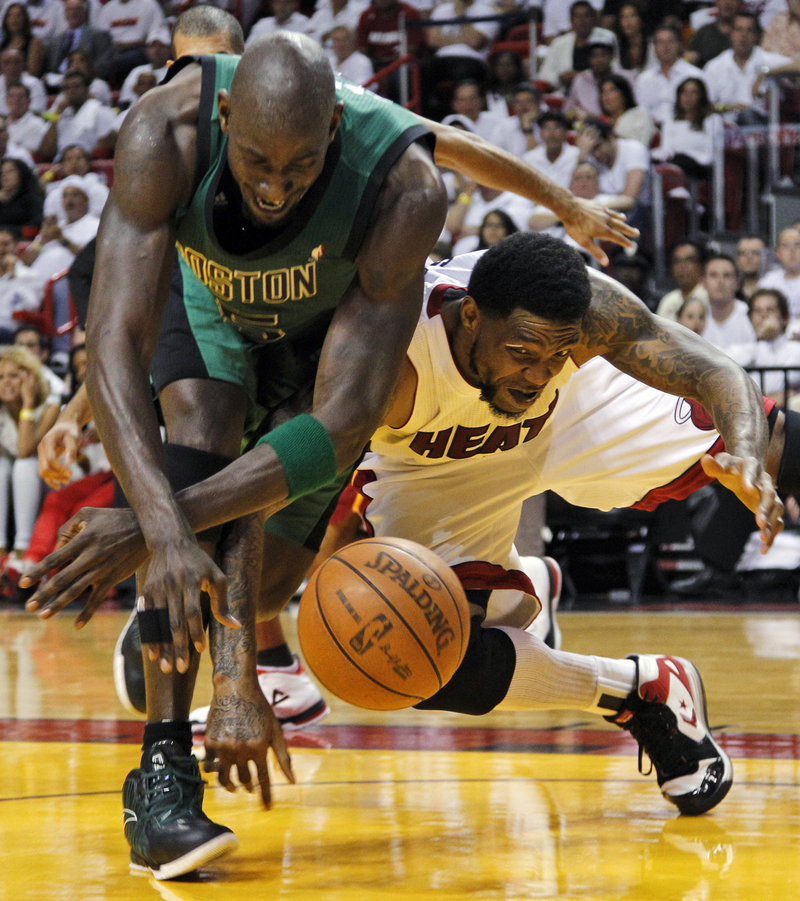Kevin Garnett of the Boston Celtics, left, and Udonis Haslem of the Miami Heat compete for a loose ball Wednesday night during the Heat’s 115-111 overtime victory.