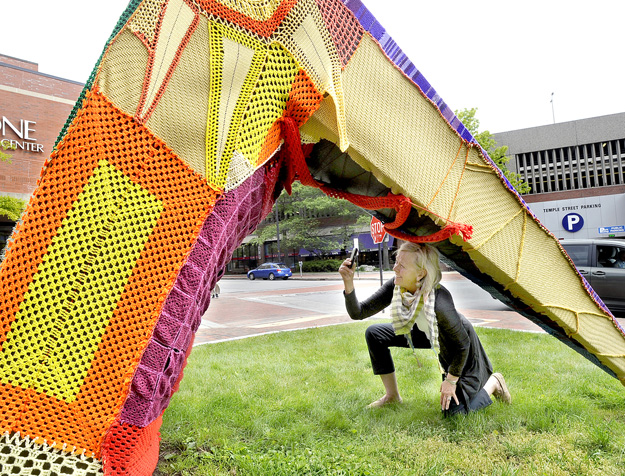 Jean Barash from Wilson, Wyo., photographs Portland's longtime sculpture "Michael" that was partially covered in yarn by people who like to take their knitting to the streets.