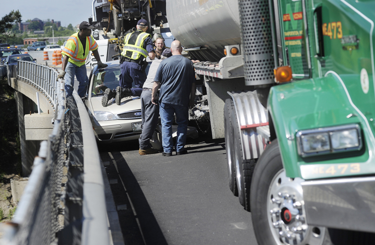 Crews work to remove a car that was wedged between a tractor trailer and the guardrail on I-295 northbound today. A tanker truck and the car collided in an area that is under construction. Northbound traffic was being detoured at Exit 4 to the Veterans Memorial Bridge while the accident was cleared this morning.