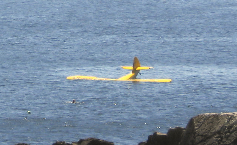 Dr. Louis Hanson’s 1946 Stinson Voyager sinks off Fort Williams Park in Cape Elizabeth on Sunday shortly after crashing into the ocean. Hanson, of Durham, can be seen in the water in front of the plane before he lost consciousness.