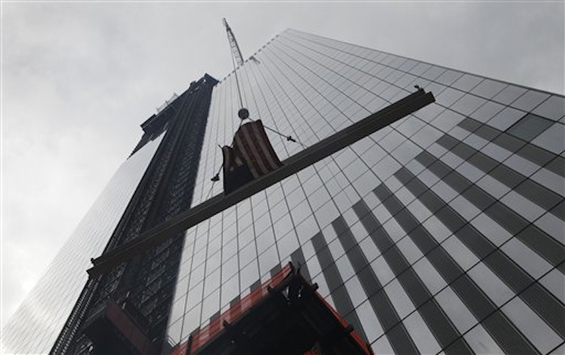 The ceremonial last beam is hoisted to the top of Four World Trade Center, Monday, June 25, 2012. The 72-floor, 977-foot tower is scheduled to open late next year. It's expected to be the first tower completed on the 16-acre site since the 9/11 attacks. (AP Photo/Mark Lennihan) Silverstein;9/11;Sept 11;ground zero