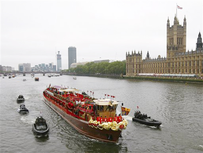The Royal Barge is seen passing the Houses of Parliament during the Thames Diamond Jubilee River Pageant in London, Sunday, June 3, 2012. More than 1,000 boats were to sail down the Thames on Sunday in a flotilla tribute to Queen Elizabeth II's 60 years on the throne that organizers are calling the biggest gathering on the river for 350 years. Despite cool, drizzly weather, hundreds of thousands of people are expected to line the riverbanks in London, feting the British monarch whose longevity has given her the status of the nation's favorite grandmother. (AP Photo/Tim Hales)