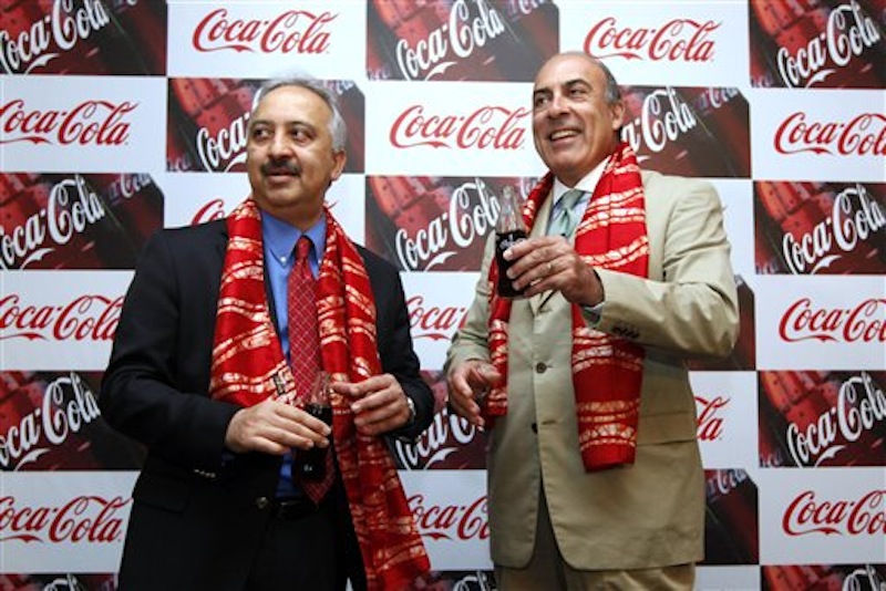 Chairman and CEO of The Coca-Cola Co., Muhtar Kent, right, holds a bottle of Coca Cola and President and CEO of Coca Cola India and South West Asia Atul Singh pose for photos before the start of a meeting in New Delhi, India, Tuesday, June 26, 2012. The world's biggest beverage maker plans to invest US$5 billion in India from 2012 to 2020. It has already invested more than US$2 billion since re-entering the country in 1993. (AP Photo/Manish Swarup)