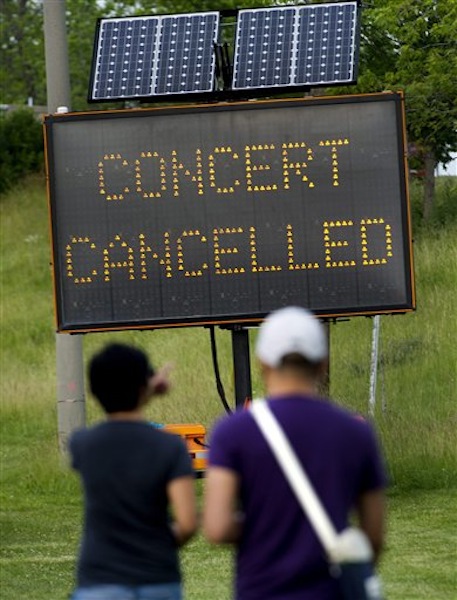 People read a sign informing of the cancellation of a Radiohead concert after a stage collapsed at Downsview Park in Toronto on Saturday, June 16, 2012. Toronto paramedics say one person is dead and another is seriously hurt after the stage collapsed while setting up for a Radiohead concert. They say two other people were injured and are being assessed. (AP Photo/The Canadian Press, Nathan Denette) injury;accident;bandage;bleeding;Canada;Canadian;care;hurt;injure;injured;internal;medical;medicine;sore;wound;wounded;health;festivals;art;arts;celebration;Ent;entertain;entertainers;entertaining;entertainment;event;events;festival;music;musician;performer;concert;artistic;band;live;performance;performing;play;playing;show;stage;general;entertainer;death;construct