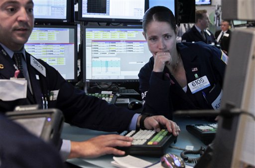 Frank Babino, left, and Amanda Anderson, right, work on the floor of the New York Stock Exchange on Wednesday, June 6, 2012. A 200-point charge turned the Dow Jones industrial average positive for the year following a dismal stretch in May. (AP Photo/Bebeto Matthews)