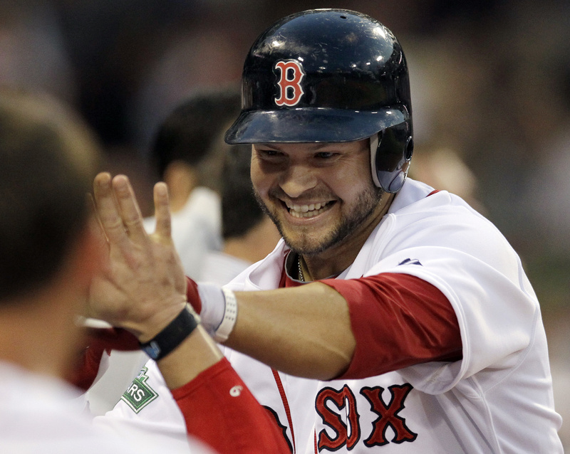 Boston Red Sox's Cody Ross is congratulated at the dugout after hitting a solo homer in the fourth inning against the Miami Marlins at Fenway Park in Boston tonight.