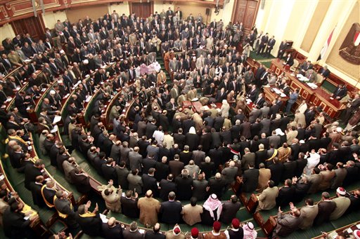 In this Jan. 23, 2012, photo, members of parliament stand and pray for the victims who died during the uprising that ousted President Hosni Mubarak. Egypt's highest court has ordered the country's Islamist-dominated parliament dissolved, saying its election about six months ago was unconstitutional.