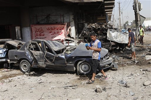 People inspect the scene of a car bomb attack in the Karrada neighborhood of Baghdad today.