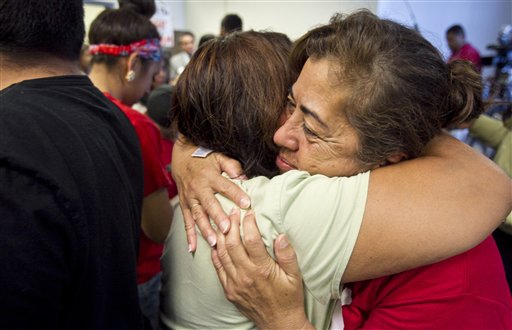 Rosa Maria Soto hugs Eva Monteloneo, left, after hearing President Obama is easing enforcement of immigration laws today in Phoenix.