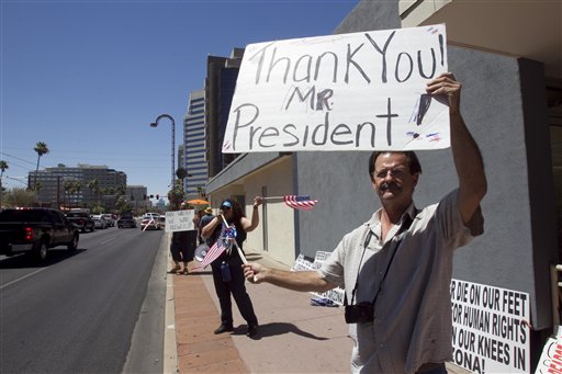 Nick Thomas, 53, of Phoenix holds up a sign Friday outside Arizona Democratic Party headquarters in a show of support for the Obama administration's decision to allow hundreds of thousands of younger illegal immigrants to stay in the country and work.