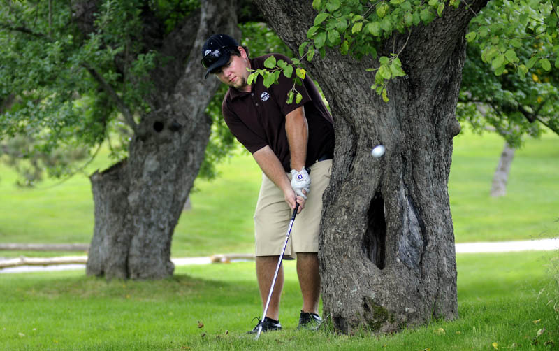 Ryan Gay of Pittston, a three-time Maine Amateur champion, hits a shot from behind a tree during the pro-am competition Monday for the Charlie’s Maine Open at Augusta Country Club. The 36-hole tournament starts today.