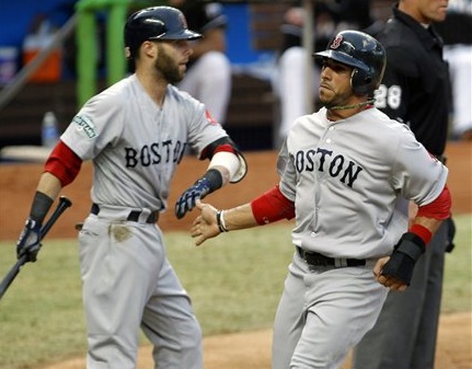 Boston's Mike Aviles, right, is congratulated by teammate Dustin Pedroia after scoring on a ground ball by Scott Podsednik against the Miami Marlins in the third inning of today's interleague baseball game in Miami.