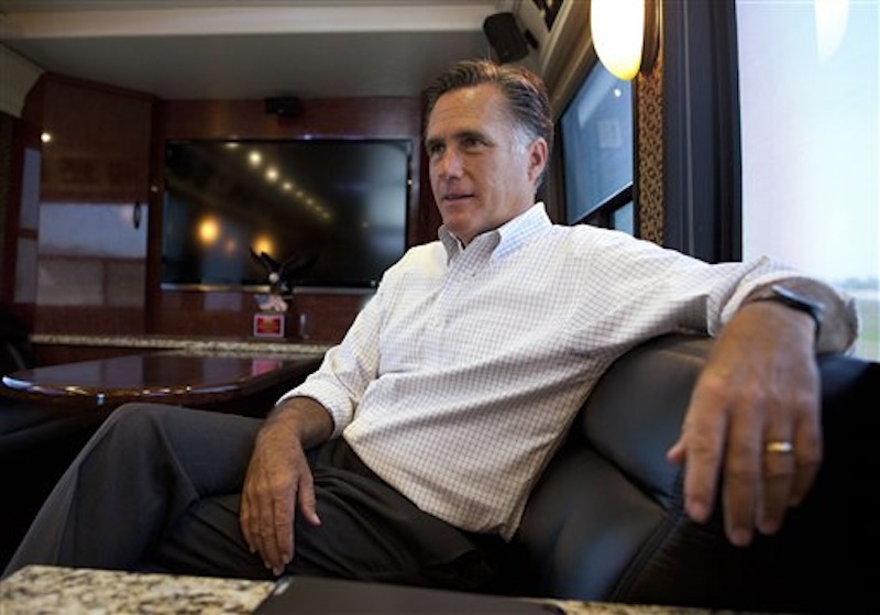 In this June 8, 2012 file photo, Republican presidential candidate, former Massachusetts Gov. Mitt Romney talks with his staff while riding on his bus after a campaign stop in Council Bluffs, Iowa. Keeping his secrets, Romney tends to lift the veil on his finances and campaign only if the law says he must. The Republican presidential candidate refuses to identify his biggest donors who "bundle" money for his campaign. He often declines to say who meets with him. He puts limits on media access to his fundraisers. And he resists releasing all of his tax returns, making just a single year public after facing pressure to do so. He says he gives out all the information that's required by law. (AP Photo/Evan Vucci, File)
