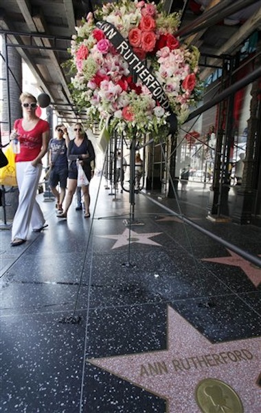 Pedestrians walk past flowers placed on the Hollywood Walk of Fame star for actress Ann Rutherford, who died in Beverly Hills on Monday, in the Hollywood section of Los Angeles Tuesday, June 12, 2012. Rutherford, the demure brunette actress who played the sweetheart in the long-running Andy Hardy series and Scarlett O'Hara's youngest sister in "Gone With the Wind," has died. She was 94. (AP Photo/Nick Ut)