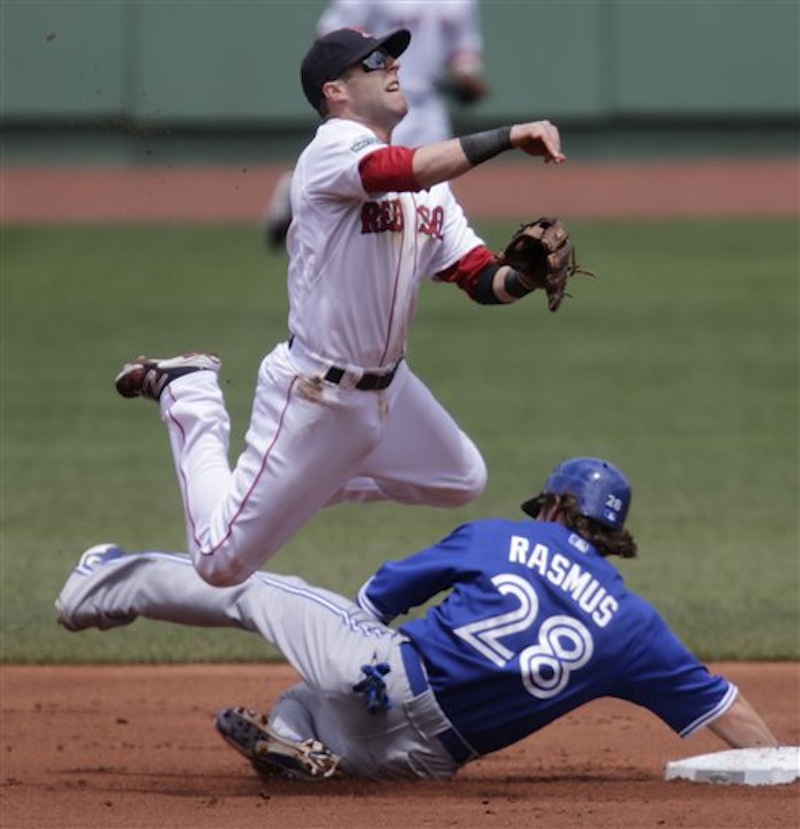 Boston Red Sox second baseman Dustin Pedroia leaps as he makes the force out on Toronto Blue Jays' Colby Rasmus on a grounder by teammate Jose Bautista in the first inning of a baseball game at Fenway Park in Boston, Wednesday, June 27, 2012. Bautista was safe at first. (AP Photo/Charles Krupa)