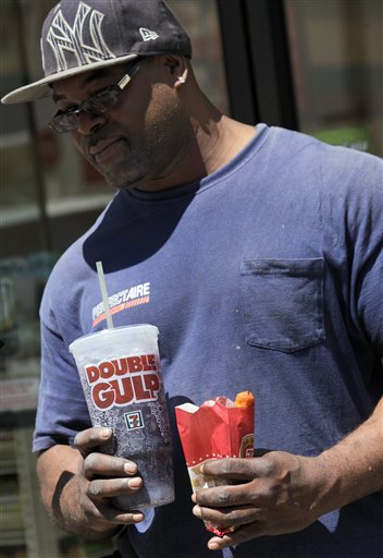 A man leaves a 7-Eleven store in New York with a 64-ounce Double Gulp drink. A poll released Monday says about half of New Yorkers don't like Mayor Michael Bloomberg's proposal to ban servings of sugary drinks over 16 ounces at city eateries.