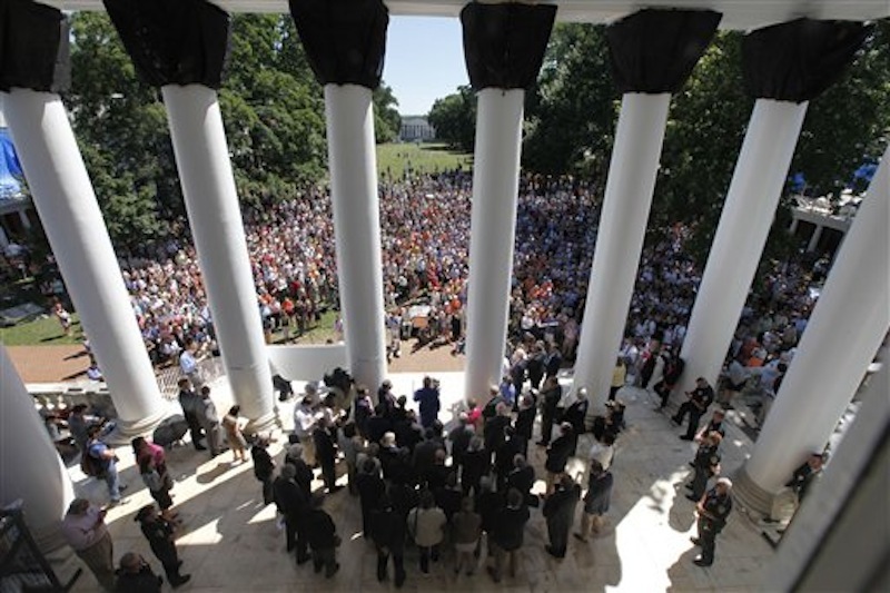 University of Virginia president Teresa Sullivan, center, at podium, addresses a crowd of supporters outside the university Rotunda after she was reinstated by the Board of Visitors during a meeting at the school Tuesday, June 26, 2012 in Charlottesville, Va. The 15-member Board of Visitors voted unanimously to reinstate Sullivan less than three weeks after ousting her in a secretive move that infuriated students and faculty, had the governor threatening to fire the entire governing board and sparked a debate about the most effective way to operate public universities in an era of tight finances. Shortly after the vote, Sullivan thanked the board members for their renewed confidence in her. (AP Photo/Steve Helber)