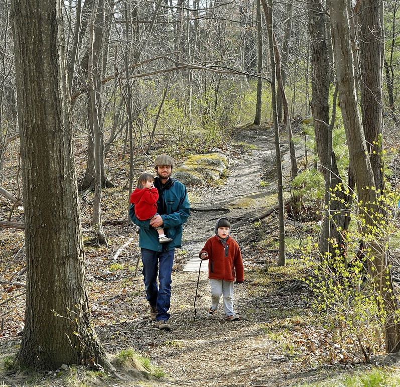 Neighborhood resident Tim Willoughby walks one of the paths in “Canco Woods,” with daughter, Maeve, 2, and son Thomas, 4, in April.