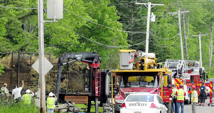 Investigators look over the logging truck where a man was electrocuted this afternoon on Spears Corner Road in West Gardiner.