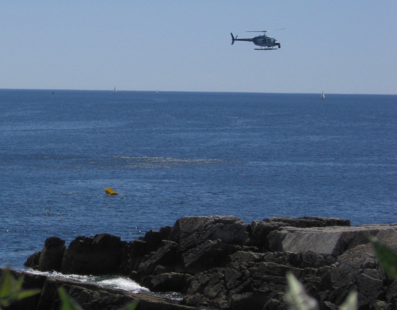 The helicopter circles as the plane sinks.