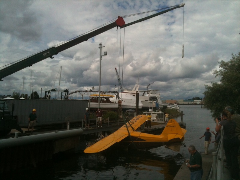The Stinson plane involved in Sunday's fatal crash at Fort Williams Park is lifted onto the dock at South Port Marine in South Portland on Tuesday, June 26, 2012.