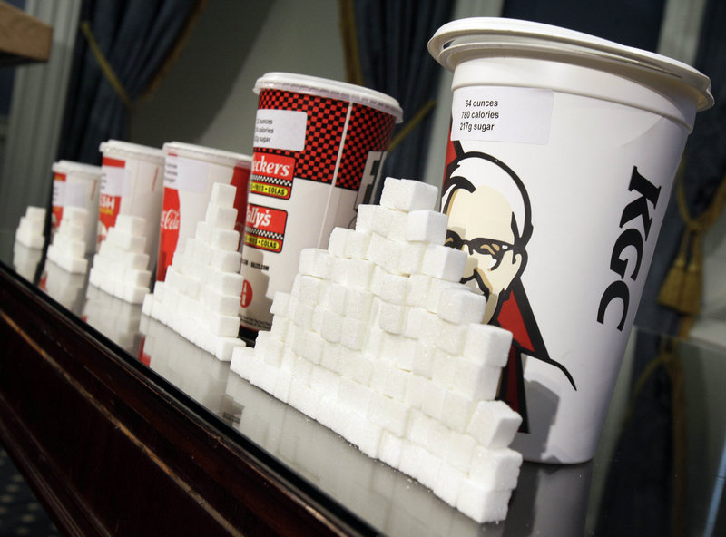 Drink cups and sugar cubes are displayed Thursday at New York City Hall, where Mayor Michael Bloomberg proposed a ban on sales of large sodas and other sugary drinks in city eateries and movie theaters.
