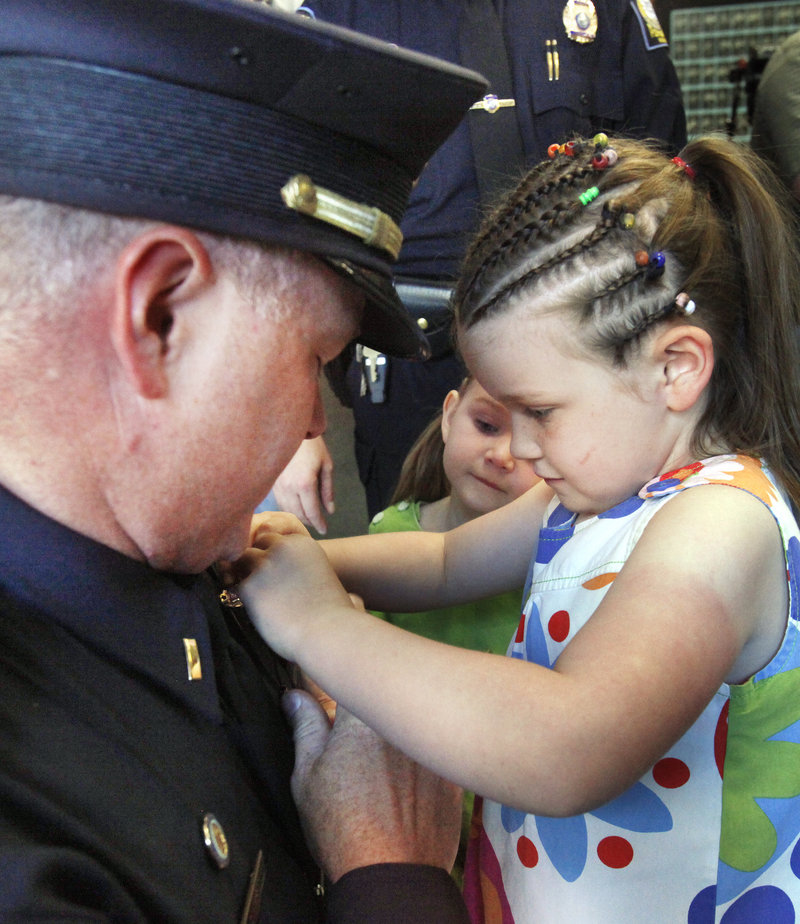 Robert Doherty Jr. gets his badge from daughters Madeline, 5, right, and Briella, 3. Doherty, a fourth-generation officer, was promoted to lieutenant.