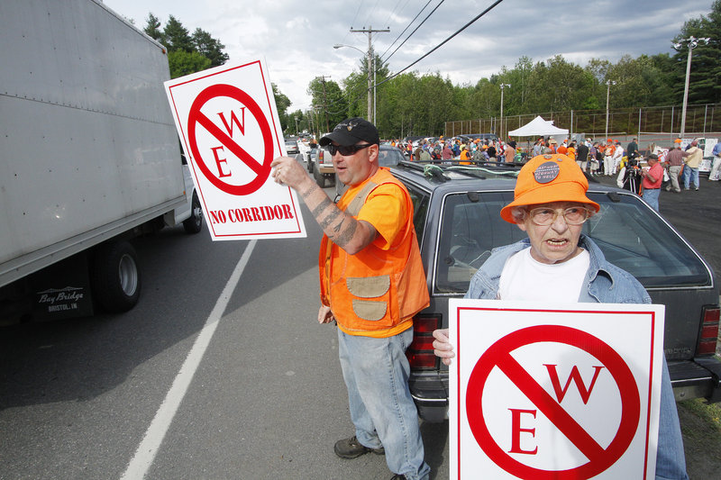 Rob Borden and Erla St. Pierre protest the proposed East-West Highway before a public meeting in Dover-Foxcroft on May 31.