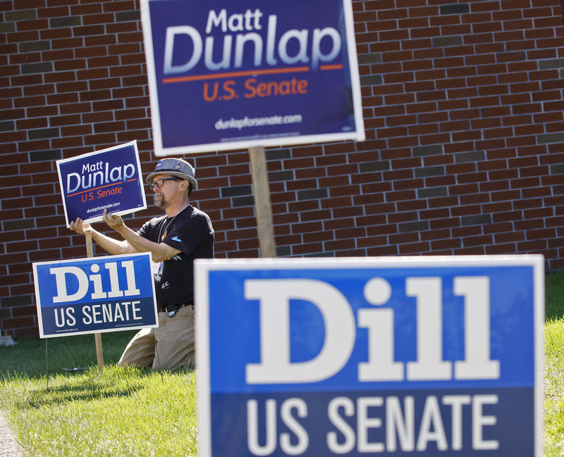 Robert O’Brien of Peaks Island, a campaign worker for U.S. Senate candidate Matt Dunlap, puts up signs before the Democratic convention at the Augusta Civic Center on Friday. Democrats are vowing to reverse losses in the 2010 elections with victories this fall.