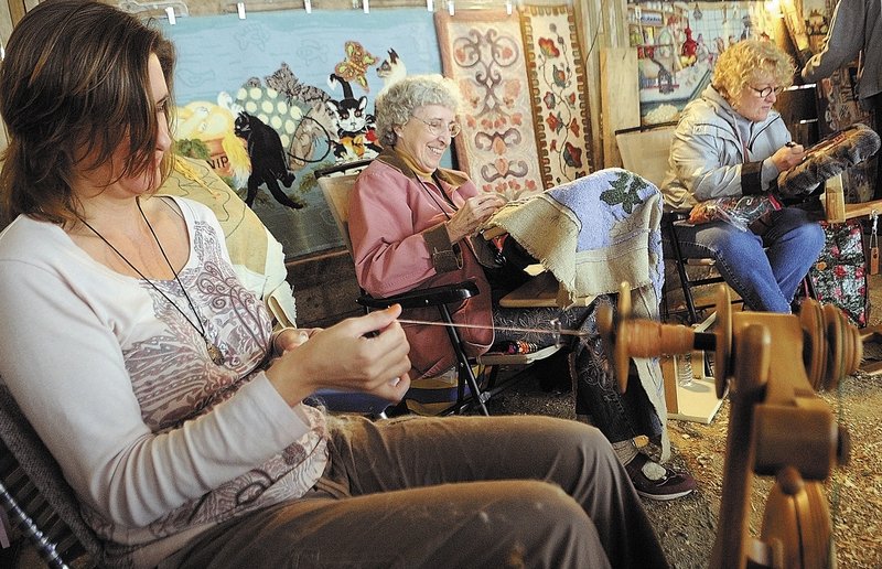 Becky Foster, left, of Harrison spins yarn as Vivian Morissette of Pittston and Julie Stewart of Litchfield hook rugs during the Fiber Frolic Fair on Saturday at the Windsor Fairgrounds. The fair continues through today. The fairgrounds are located on Route 32 between routes 17 and 105.